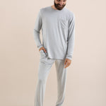 Man wearing a light gray long-sleeve top and pants on a beige background