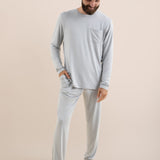 Man wearing a light gray long-sleeve top and pants on a beige background