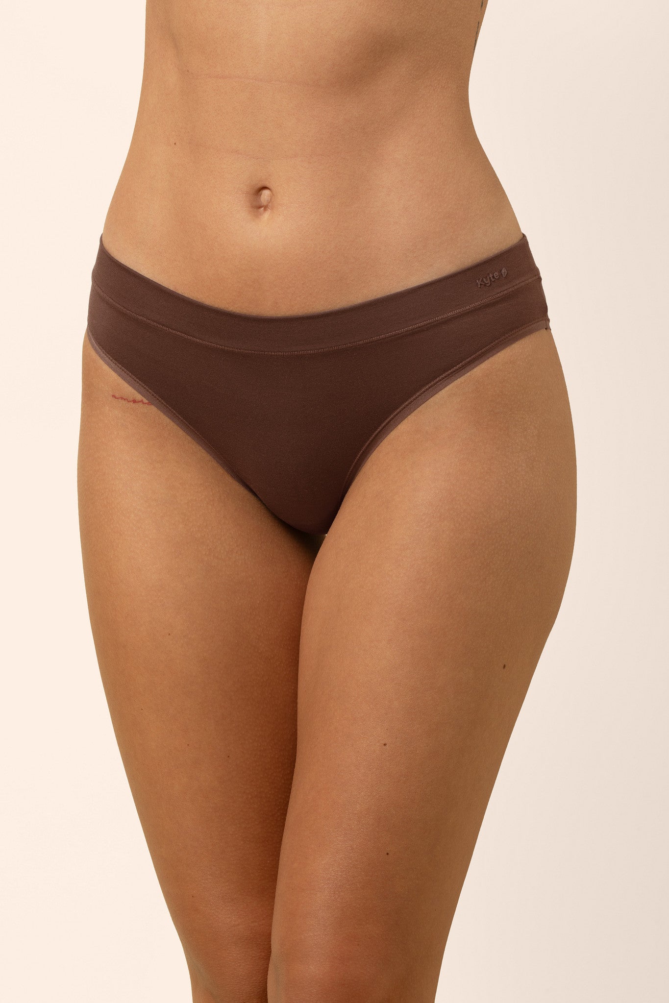 Brown underwear worn by a person on a beige background