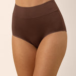 Brown high-waisted underwear worn by a person on a beige background