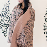 Model wrapped in the Kyte Throw Blanket in Latte Leopard 2.5 TOG