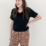 Woman laughing and modeling the Lounge Pants in Latte Leopard paired with a black V Neck