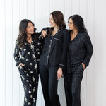 Models wearing the Kyte Long Sleeve Women's Pajama Set in Midnight  Magnolia, Midnight with Cloud Trim and Midnight Leopard