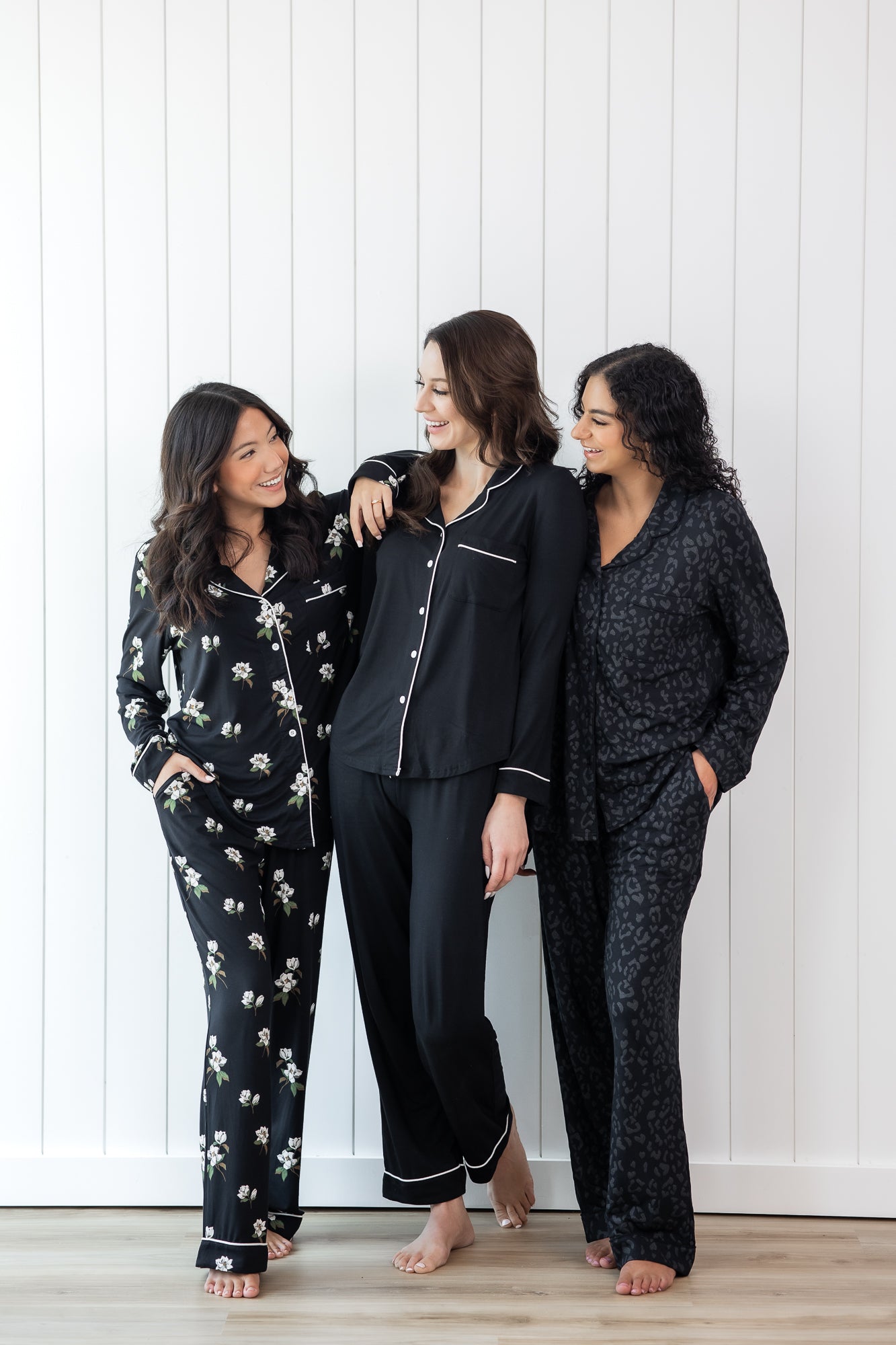 Models wearing the Kyte Long Sleeve Women's Pajama Set in Midnight  Magnolia, Midnight with Cloud Trim and Midnight Leopard