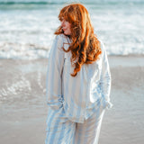 Woman modeling big mist stripe pajamas on the beach 