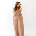 Woman with arms around herself while wearing the Adult Sleep Bag Walker in Latte
