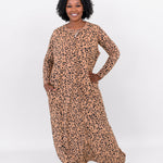 Smiling woman modeling Kyte Adult Sleep Bag Walker in Latte Leopard and matching long sleeve top beneath it