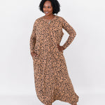 Woman modeling the Kyte Adult Sleep Bag Walker in Latte Leopard with matching top layered beneath it