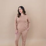 Woman looking to the side while modeling the Kyte Women's Jogger Set in Latte