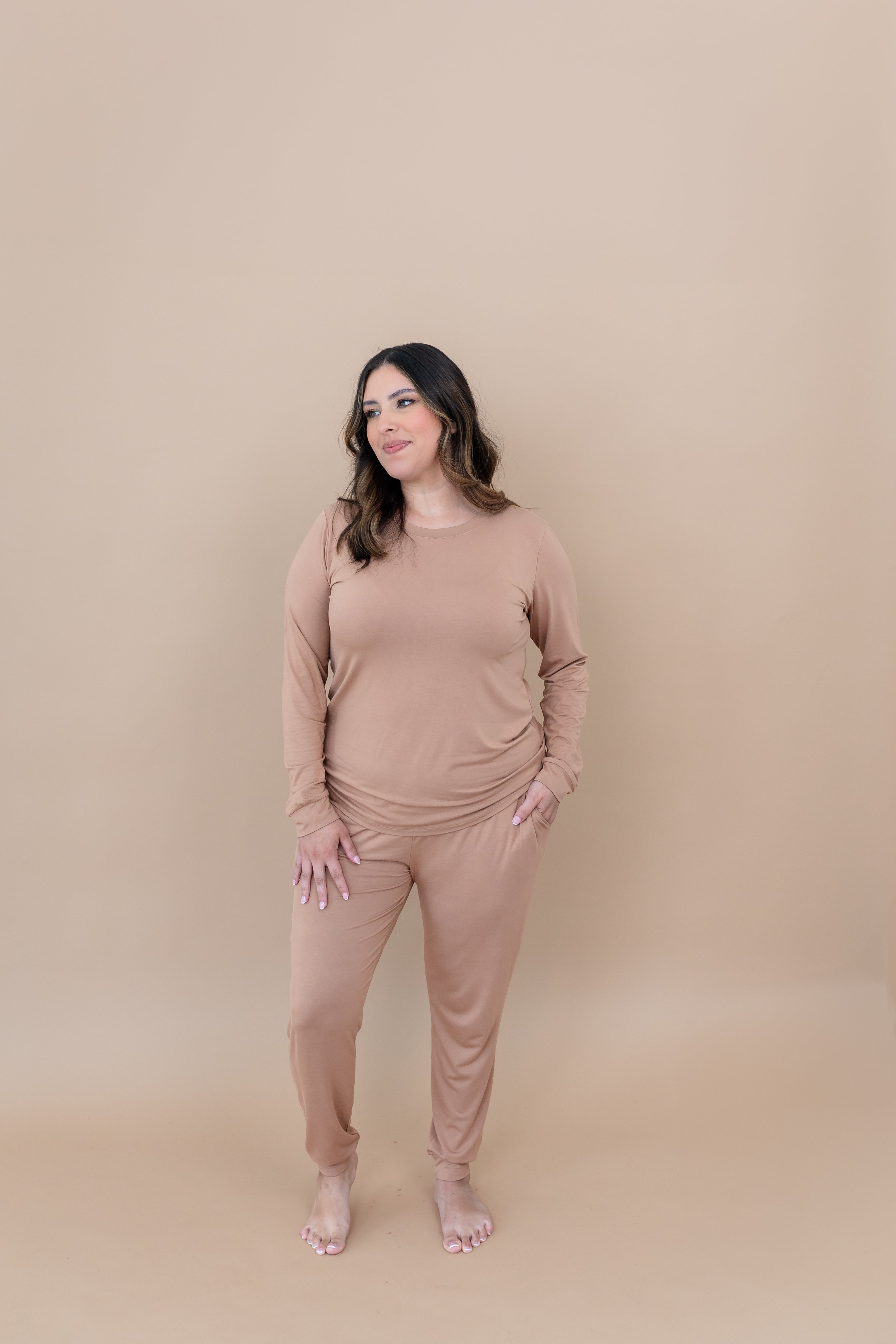 Woman looking to the side while modeling the Kyte Women's Jogger Set in Latte