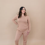 Model with hand on her hip while wearing the  Kyte Women's Jogger Set in Latte