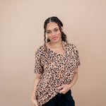 Woman modeling the Women's V Neck Tee in Latte Leopard paired with black pants