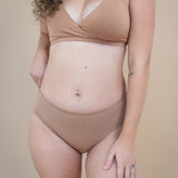 Woman wearing matching light brown bralette and underwear 