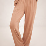 The pants of the Long-Sleeved Women's Pajama Set in Latte with Latte Trim shown on a model