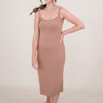 Woman looking to the side with one arm on hip while she models the  Ribbed Cami Dress in Latte