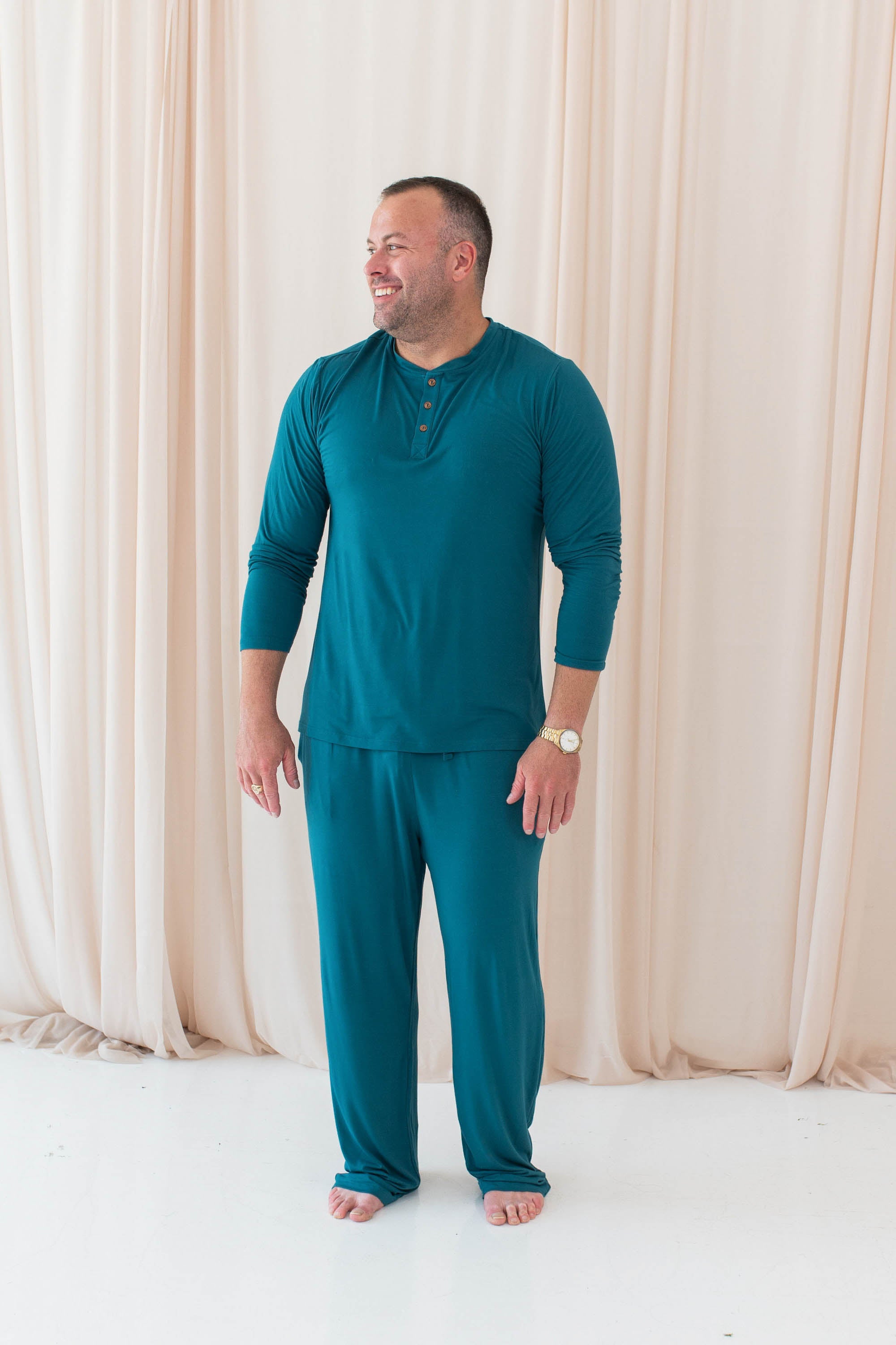 Male model wearing the Men's Long Sleeve Henley Top in Loch paired with the Men's Lounge Pants in Loch