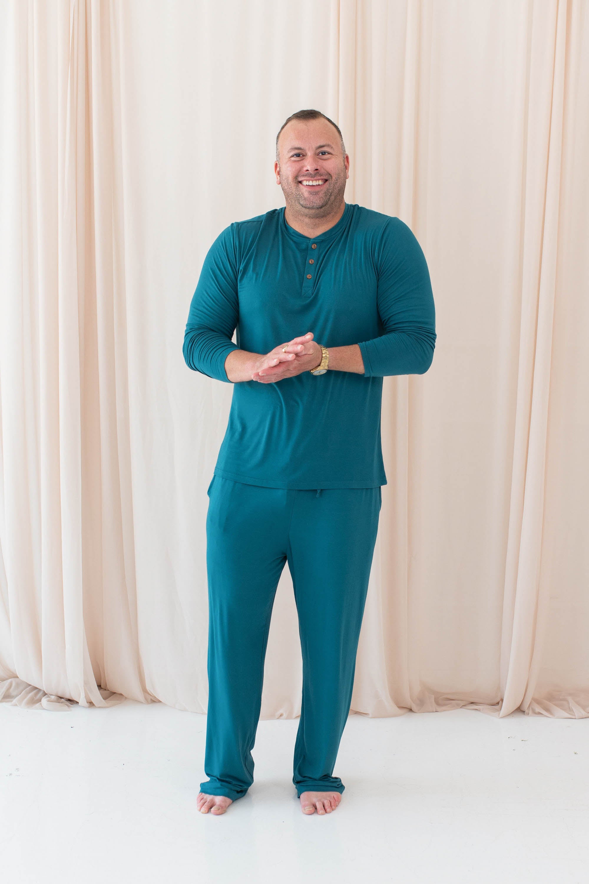 Smiling model in the Men's Long Sleeve Henley Top in Loch paired with Men's Lounge Pants in Loch