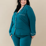 Female modeling Kyte Baby's Women's Long Sleeve Pajama Set in Loch with Cloud Trim
