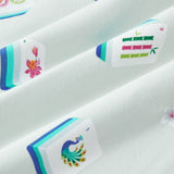 An all-over print featuring: white Mahjong tiles with a navy and turquoise back and various artworks; white jasmine flowers with pink centers and green leaves; white dice with pink, turquoise, and green markings; and turquoise teacups with navy trim, over a pale turquoise background color named Dew.