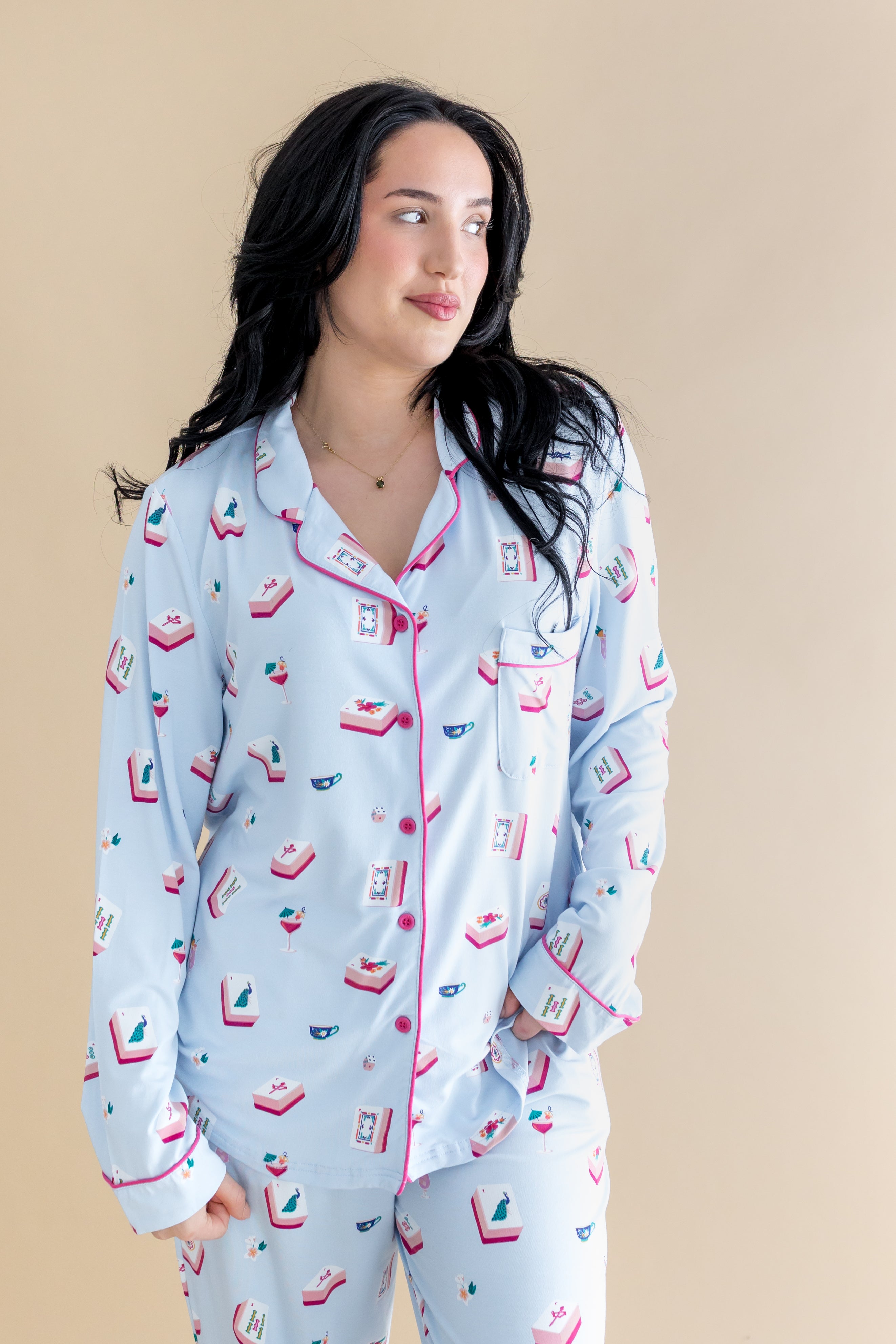 Woman wearing a light blue pajama set with colorful patterns against a beige background