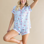 Woman wearing a light blue pajama set with pink accents and a Mahjong pattern on a beige background