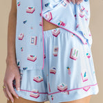 Light blue pajama set with pink trim featuring Mahjong designs on a beige background