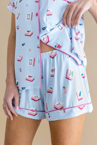 Light blue pajama set with pink trim featuring Mahjong designs on a beige background