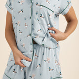 Light blue pajama set with duck pattern worn by a person on a beige background