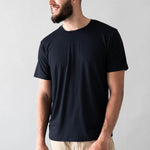 Smiling male wearing the Men's Crew Neck Tee in Midnight in Khaki colored pants