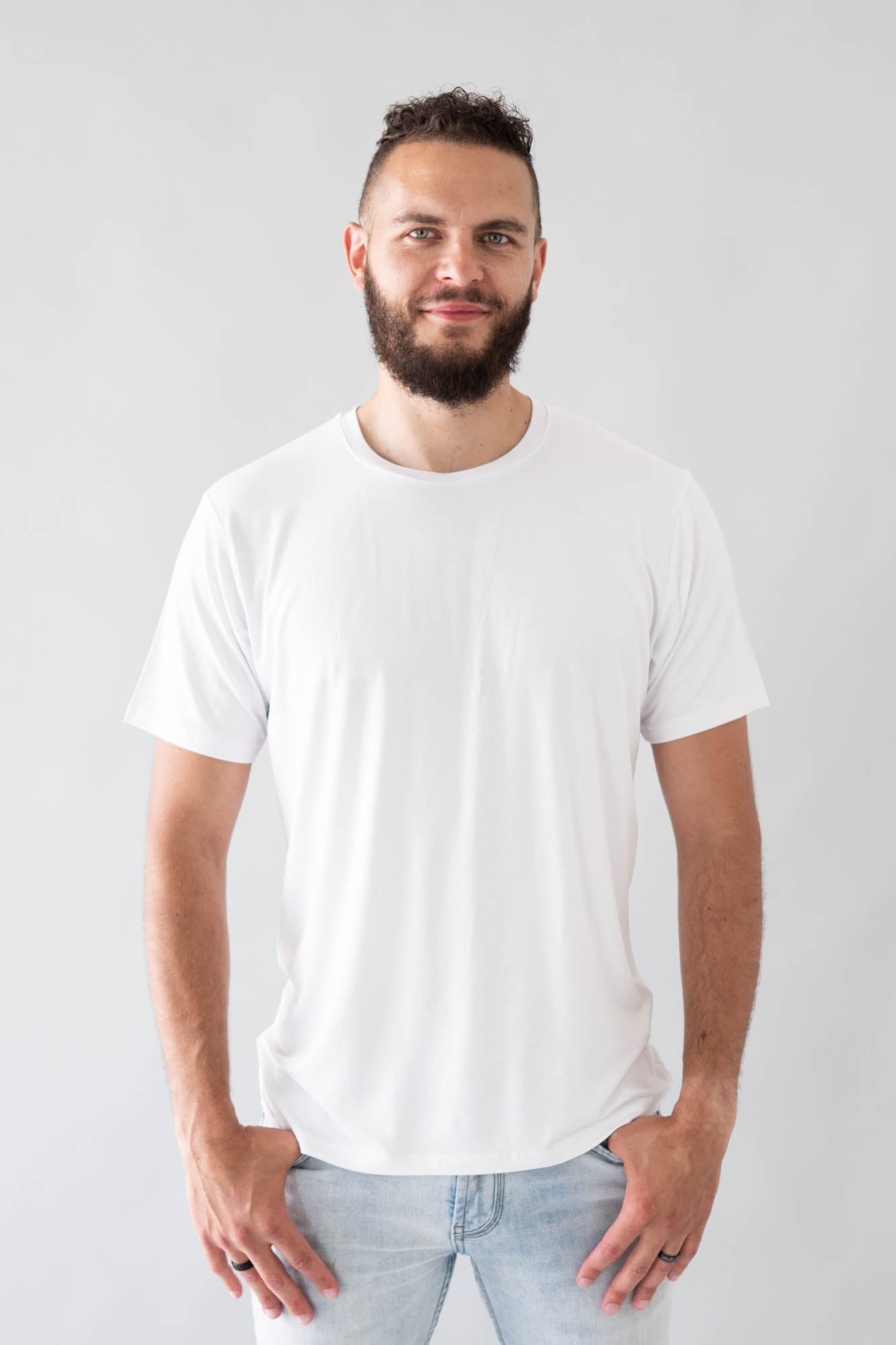 Male model wearing the Men's Crew Neck Tee in Snow with light wash jeans