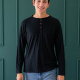 Smiling model in the Men's Long Sleeve Henley Top in Midnight and medium wash pants
