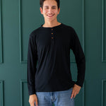 Male model wearing the Men's Long Sleeve Henley Top in Midnight and medium wash jeans