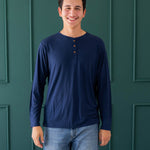 Male model wearing the Men's Long Sleeve Henley Top in Navy and medium wash jeans