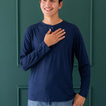 Smiling male wearing the Men's Long Sleeve Henley Top in Navy paired with light wash jeans