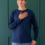 Smiling male wearing the Men's Long Sleeve Henley Top in Navy paired with light wash jeans