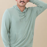 Male model wearing the Men's Ribbed Hoodie in Thyme with one arm up and behind his head