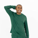 Smiling male model wearing the Men's Jogger Set in Evergreen with one hand up and behind his head