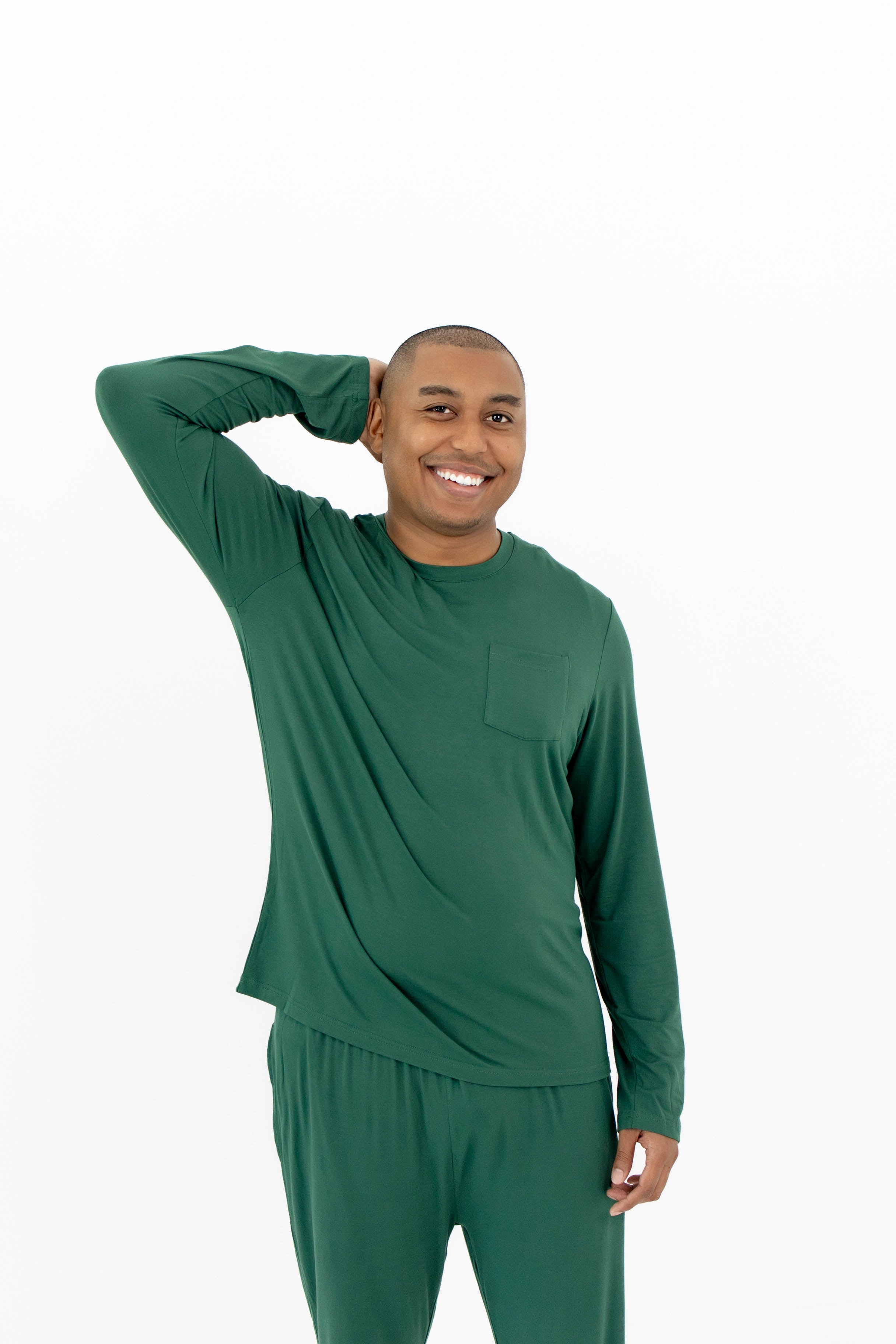 Smiling male model wearing the Men's Jogger Set in Evergreen with one hand up and behind his head