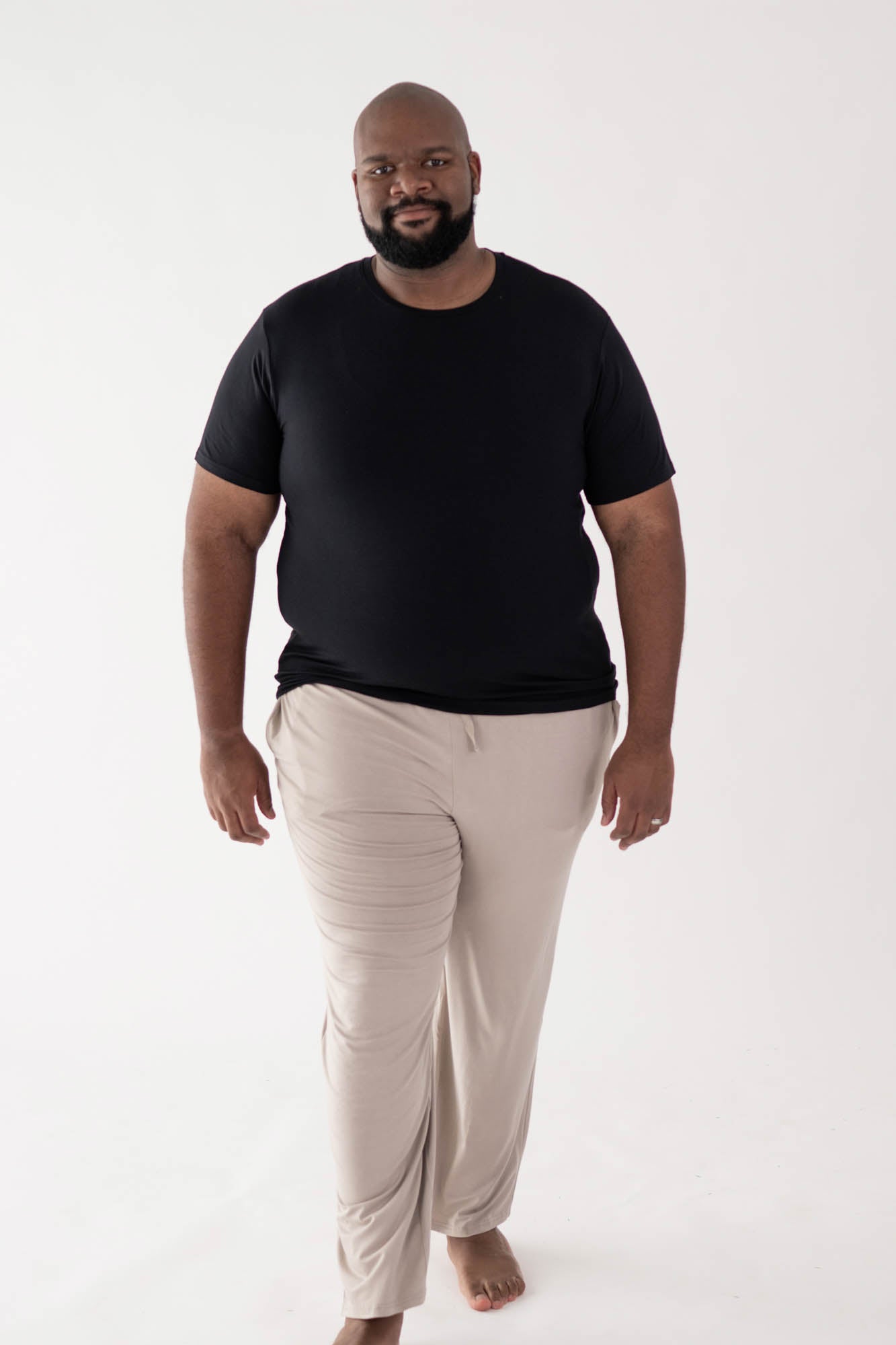 Male model walking in Men's Crew Neck Tee in Midnight and Men's Oat Lounge Pants