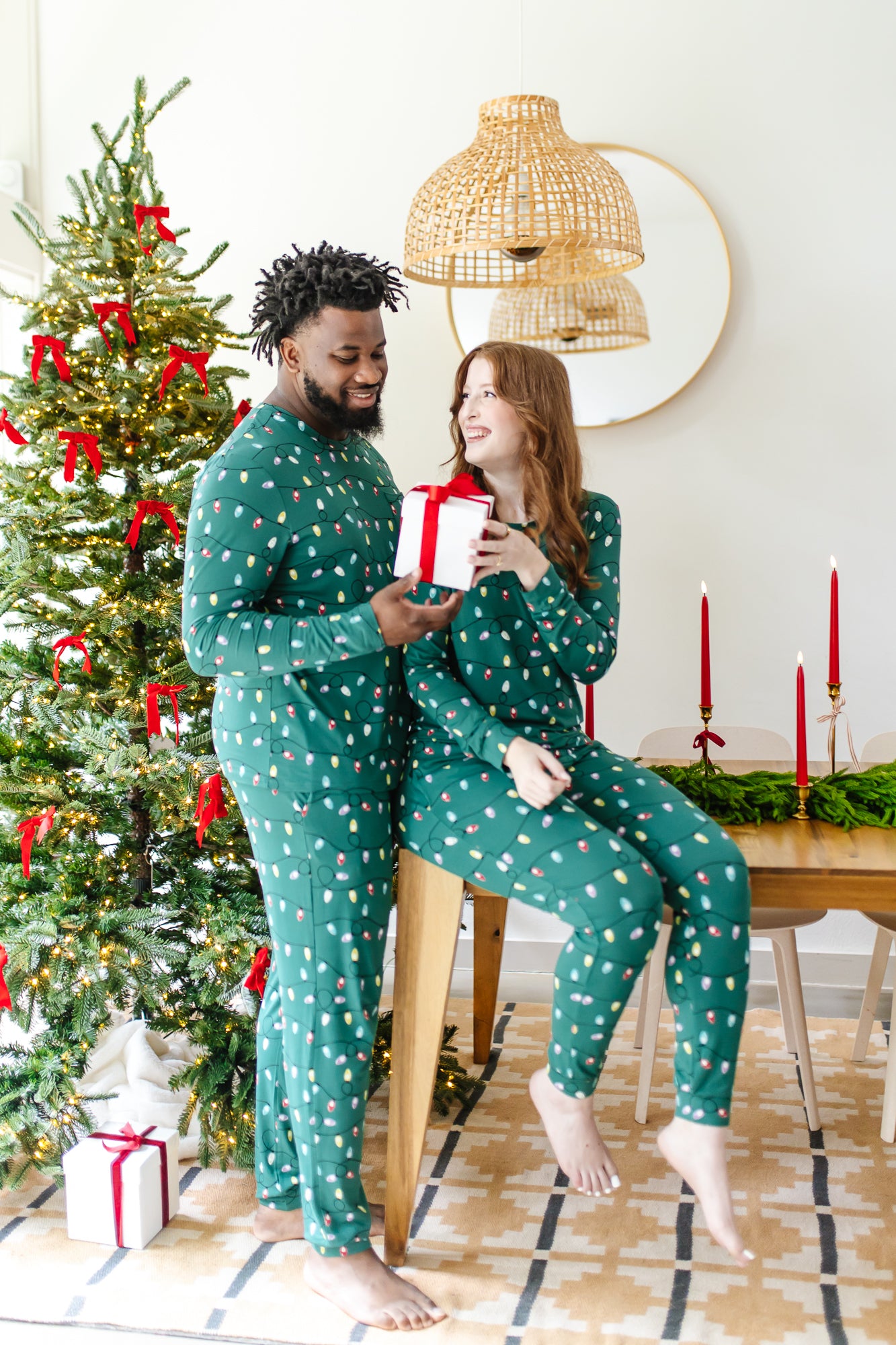 Couple wearing matching  Jogger Sets in  Merry and Bright in front of a Christmas tree