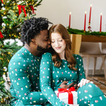Couple snuggling in front of a Christmas tree wearing matching Jogger Sets in  Merry and Bright