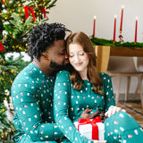 Couple snuggling in front of a Christmas tree wearing matching Jogger Sets in  Merry and Bright