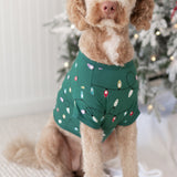 Large dog wearing the Dog Tee in Merry and Bright standing beside a decorated Christmas tree