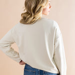 Model showcasing the back side of the Women's Sweatshirt in Mickey and Friends on Ecru