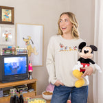 Woman wearing a sweatshirt with mickey and friends graphic on the front