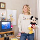 Woman wearing a sweatshirt with mickey and friends graphic on the front