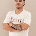 Male model wearing the Men's Crew Neck Tee in Mickey and Friends on Ecru with his arms crossed in front of his chest