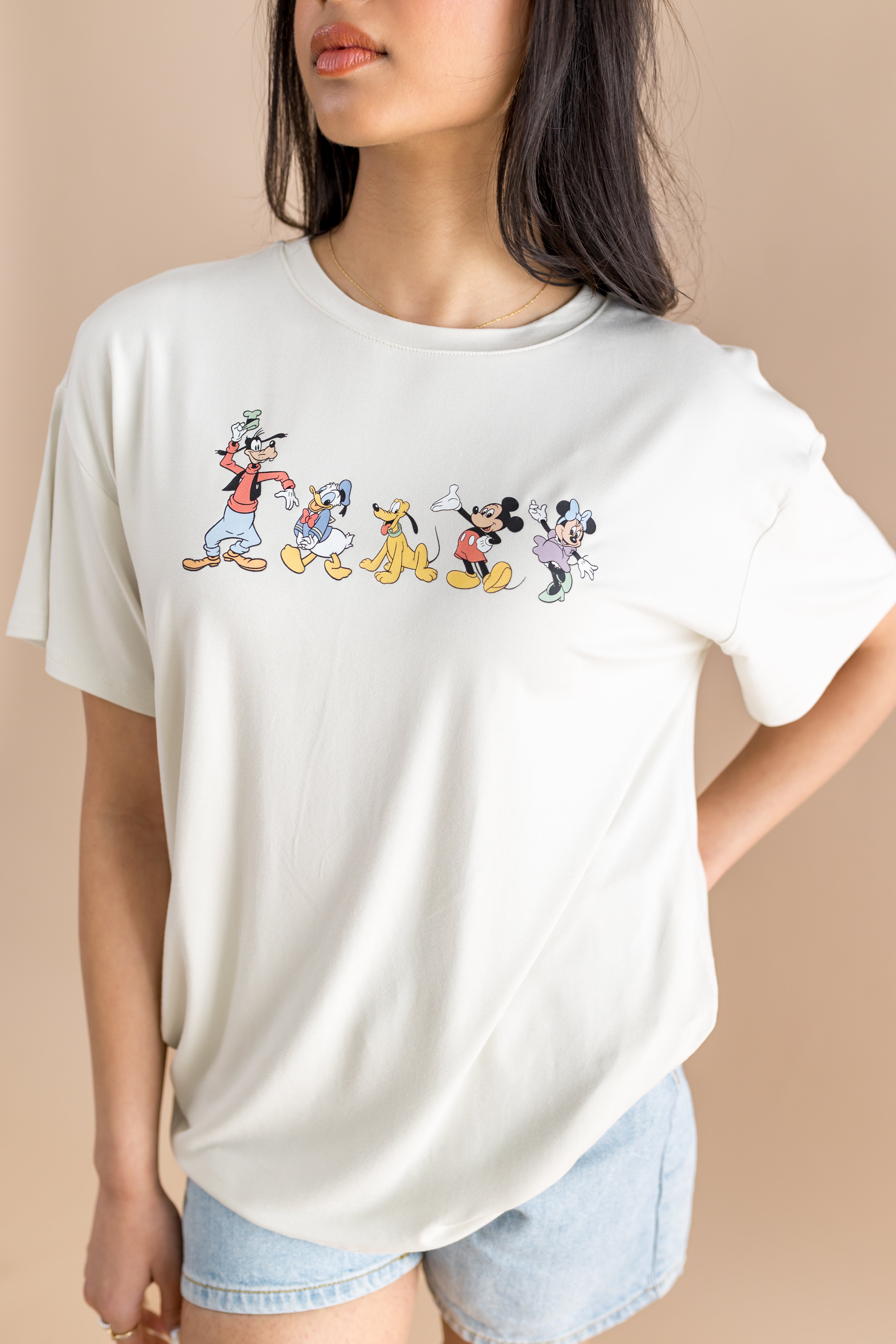 Close up of the Women's Graphic Tee in Mickey and Friends on Ecru  on a model paired with jean shorts