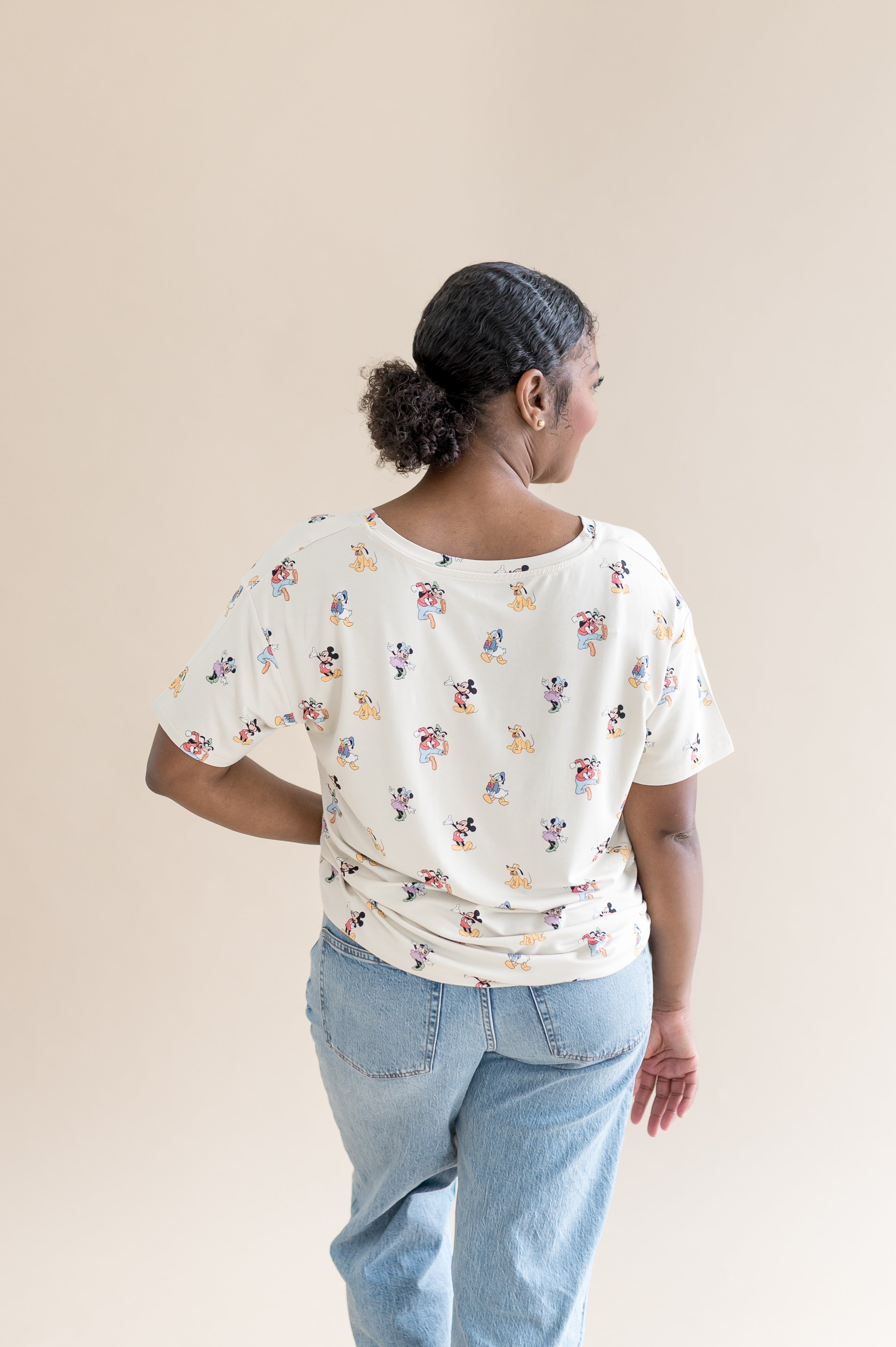 Back of the model wearing the Women's Relaxed Fit V-Neck in Mickey Mouse and Friends