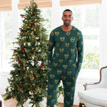Man standing in front of decorated Christmas tree wearing Men's Jogger Set in Mickey Christmas Wreath print